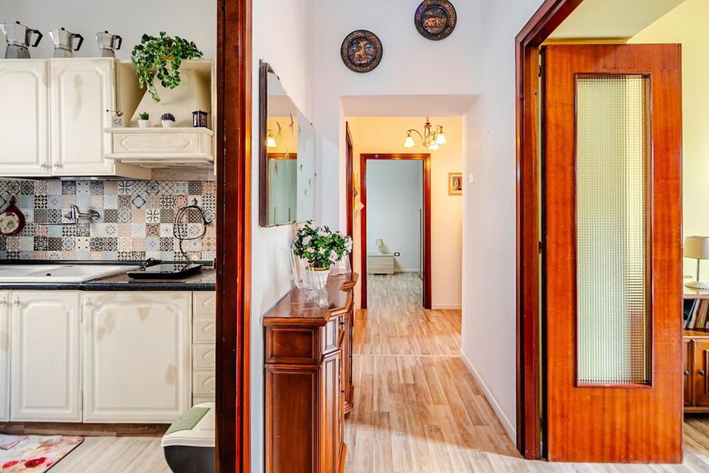a kitchen with white cabinets and a table with a mirror at Nido della Rondine in Bagnoregio