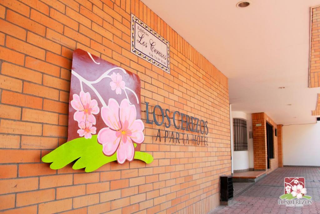 a brick wall with a painting of flowers on it at Apartahotel Los Cerezos in Neiva