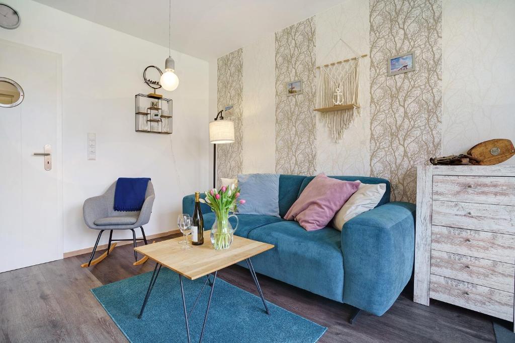 a living room with a blue couch and a table at Nordisch Kühl in Mariendorf