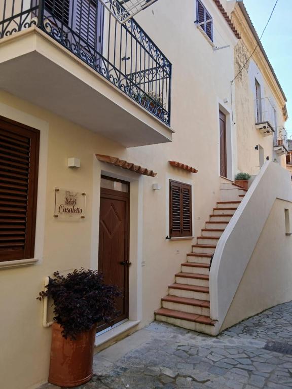 a building with a staircase and a door at B&B Casaletto in San Nicola Arcella
