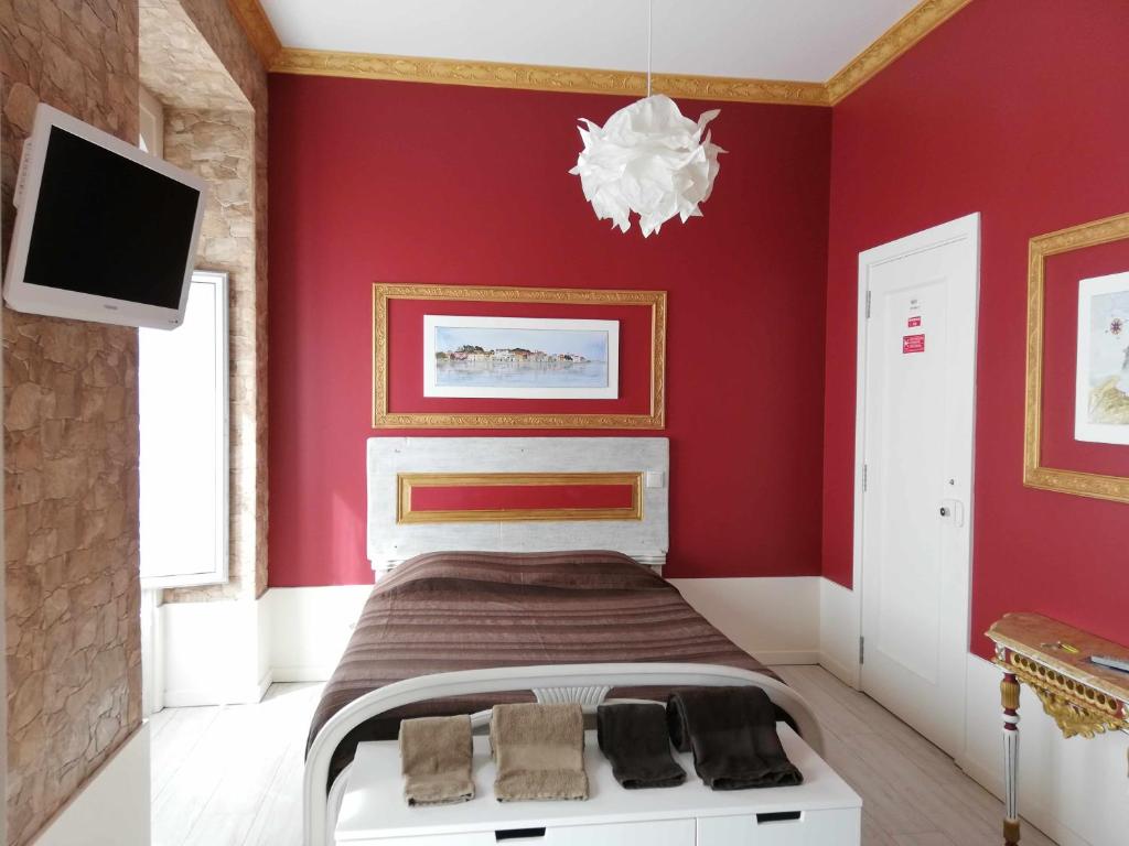 a red bedroom with a bed and a tv at Legendary Bay - Suíte Temática in Seixal