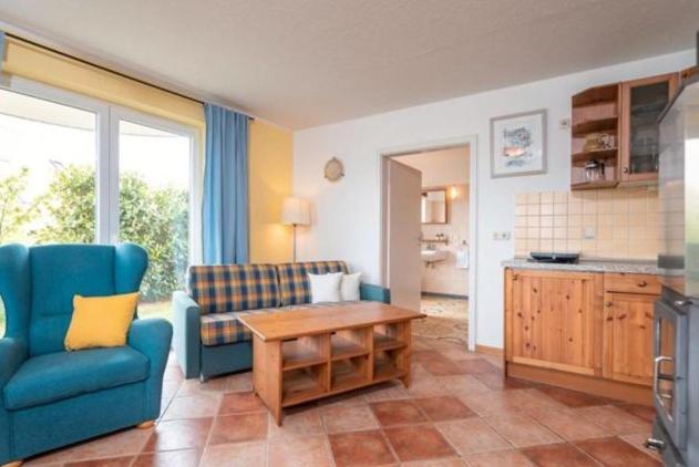 a living room with a blue couch and a table at Dia Mare EG West in Ueckeritz