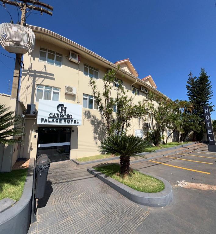 a building with a parking lot in front of it at Cardoso Palace Hotel Rio Verde in Rio Verde