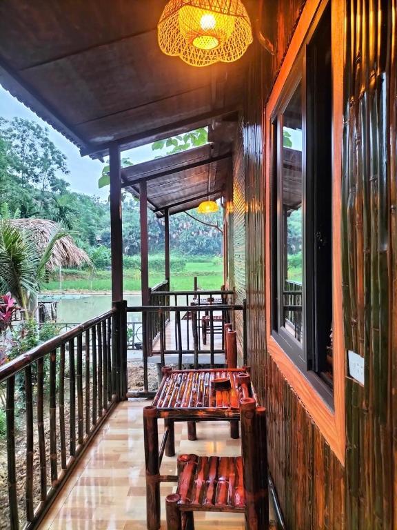 a porch with a bench on a house at Nam house - vulinh Homestay&bungalow in Vũ Linh