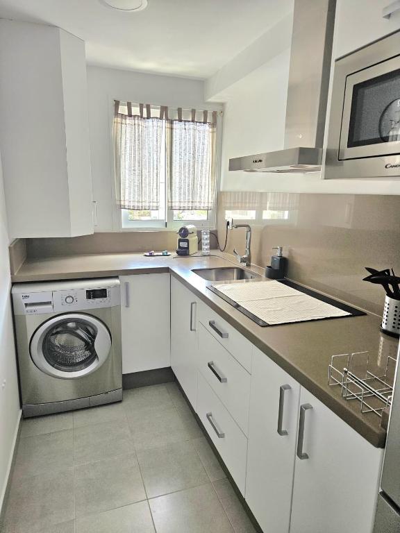 a kitchen with a sink and a washing machine at El capricho in Fuengirola