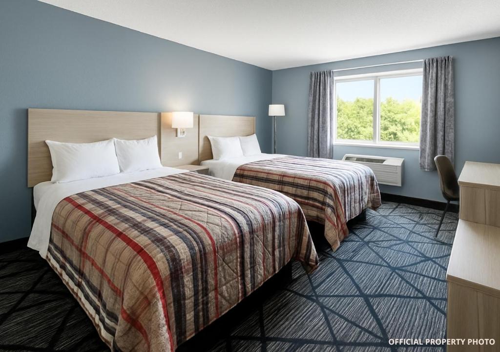 a hotel room with two beds and a window at Hotel Butler Inn in Butler