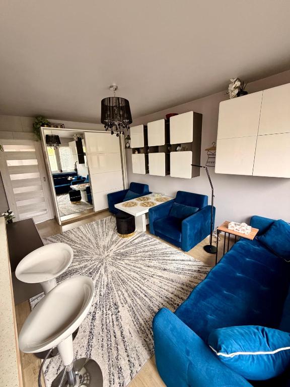 a living room with a blue couch and a table at Glamour Apartment in Konin