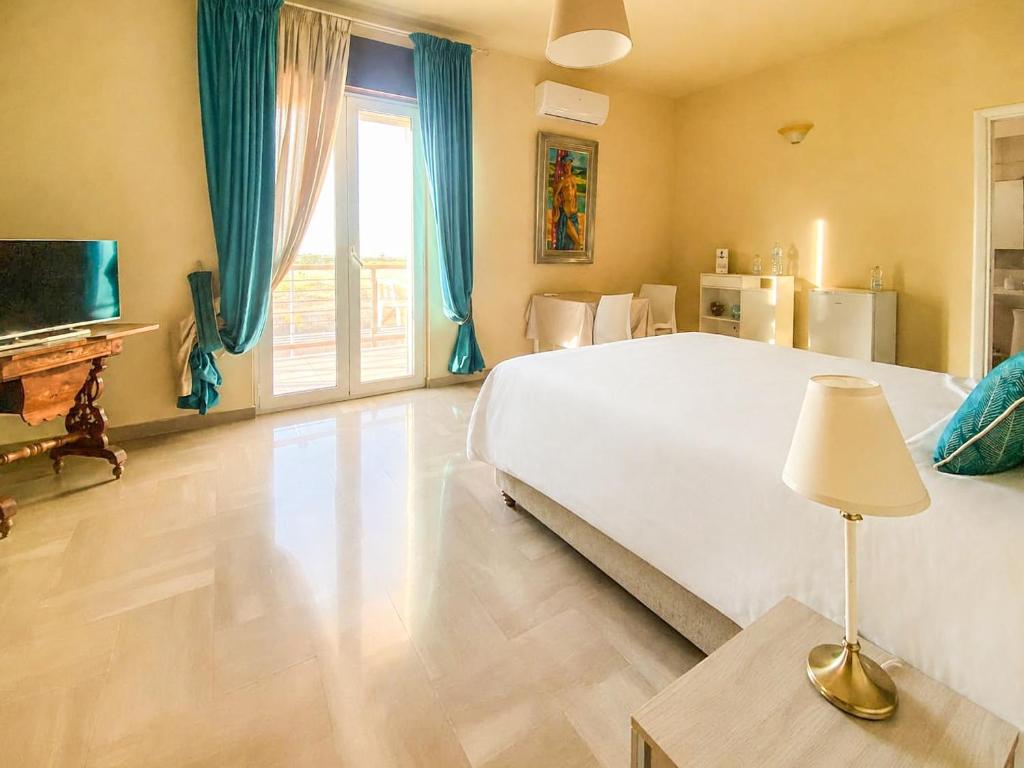 a bedroom with a large white bed and a television at Blue Room - Camera Matrimoniale con Garage Privato in Bitonto