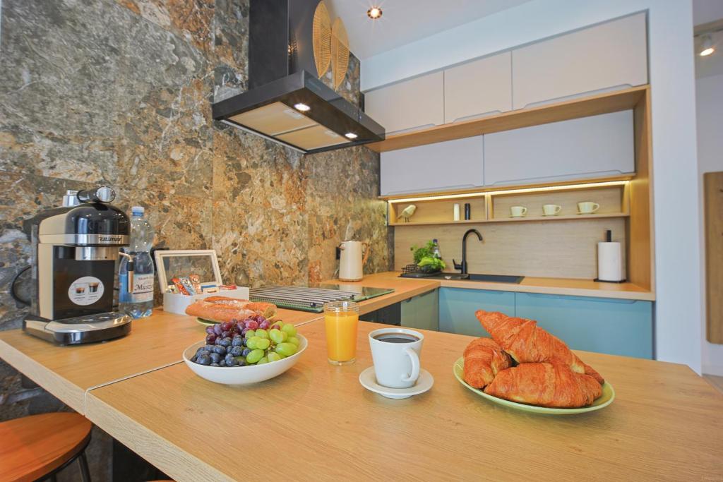 a kitchen with a table with bread and fruit on it at Mała Poleska - przytulny apartament z ogródkiem in Częstochowa