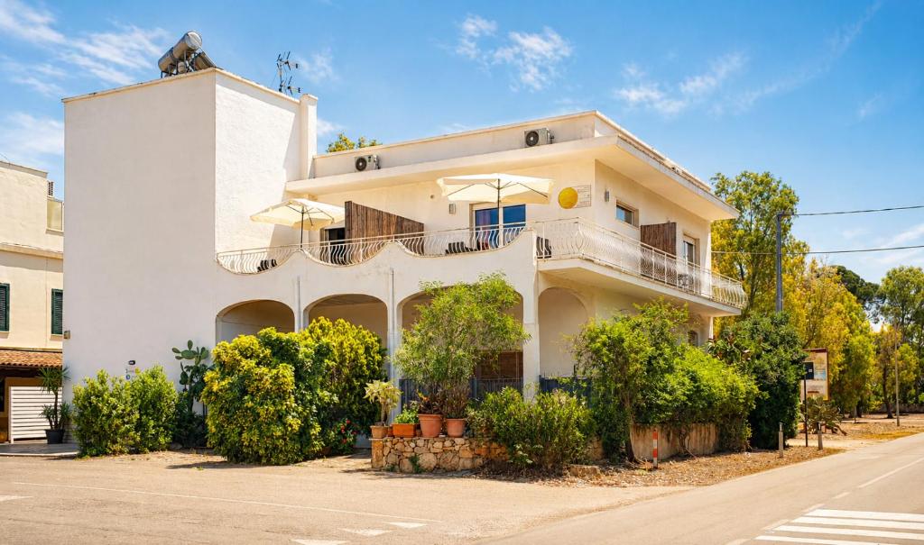 a white house with a balcony on a street at RestHouse The Village in Nardò