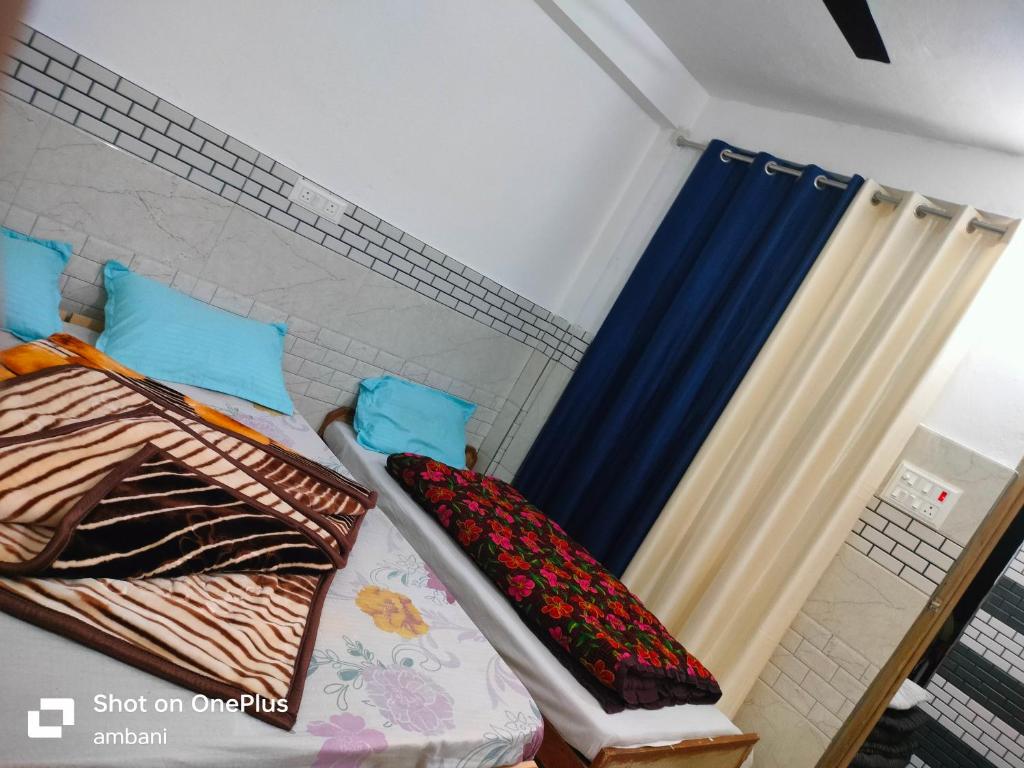 a room with two beds and a curtain at Hotel suryoday kharadi in Barkot