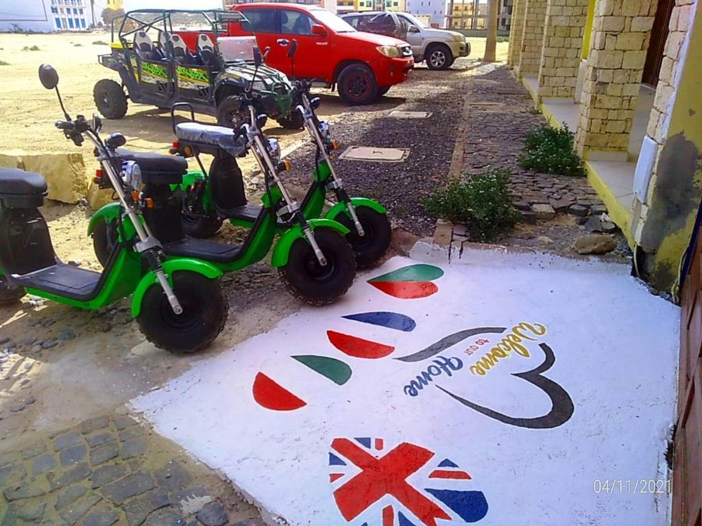 two scooters parked in a parking lot with british flags at aparthotelboavista-net in Sal Rei