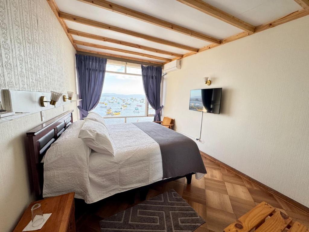 a bedroom with a large bed and a window at Hotel Panorámico Tongoy in Coquimbo