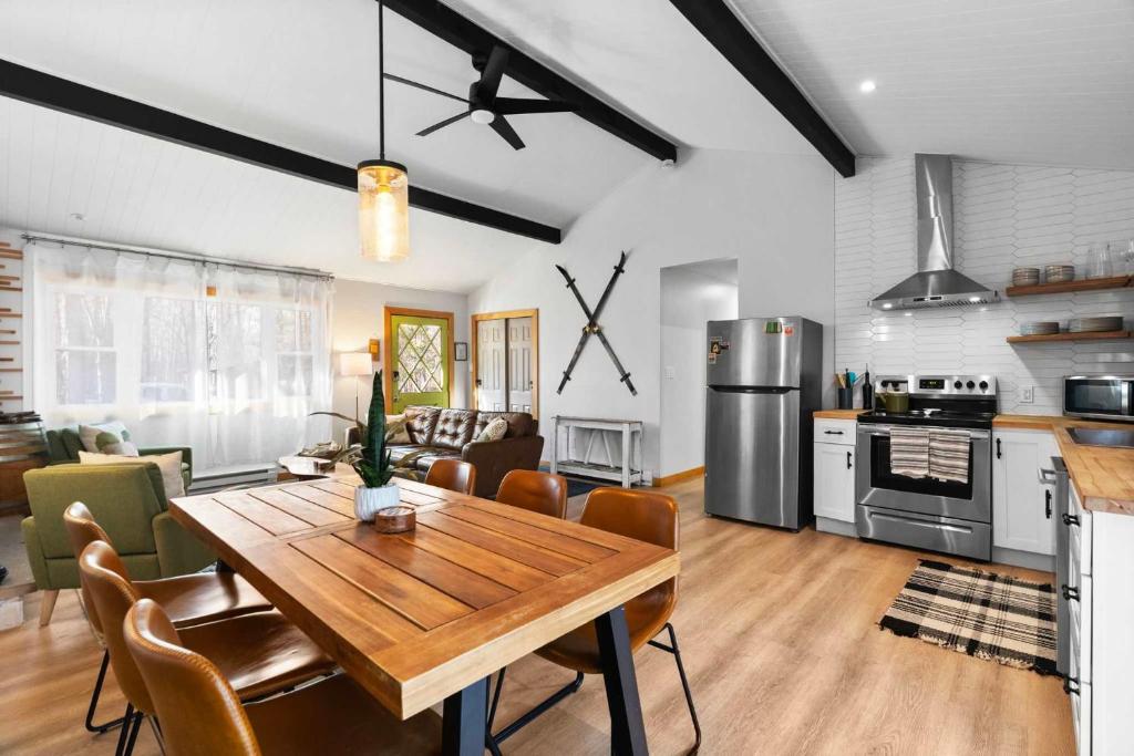 a kitchen and living room with a wooden table in a room at Firepit Game Room Seclusion and More in Locust Lakes Village