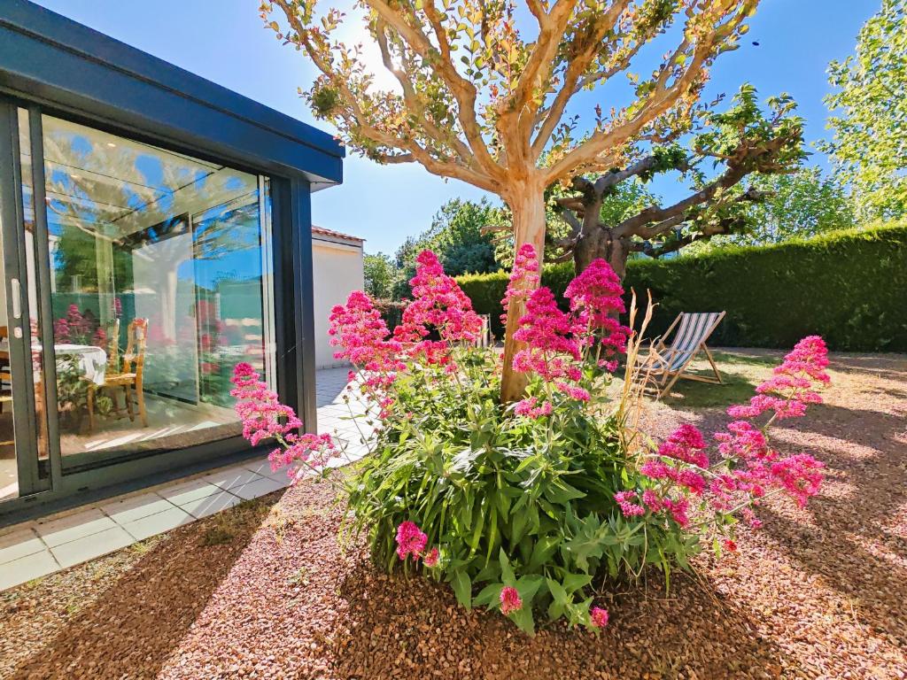 a garden with pink flowers in front of a house at La Pause Jardaise in Jard-sur-Mer