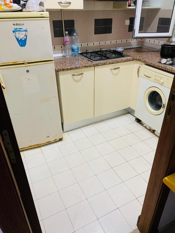 a kitchen with a refrigerator and a washing machine at Omrane in Tunis