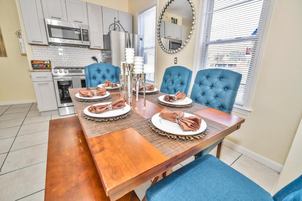 a dining room with a wooden table and blue chairs at Comfort Stay in Boston