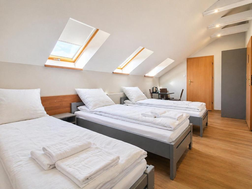 three beds in a room with skylights at Pokoje Noclegowe Sierpów in Sierpów