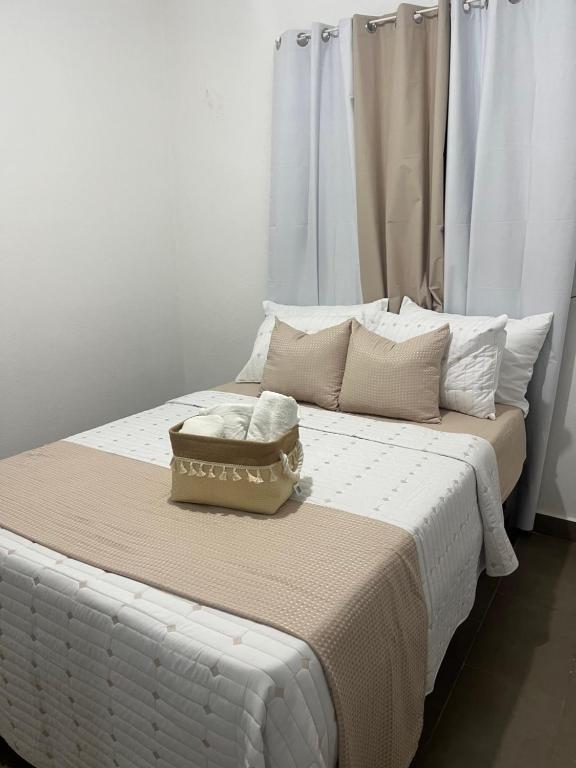 a white bed with a box on top of it at Calm Stay Monte Plata in Monte Plata