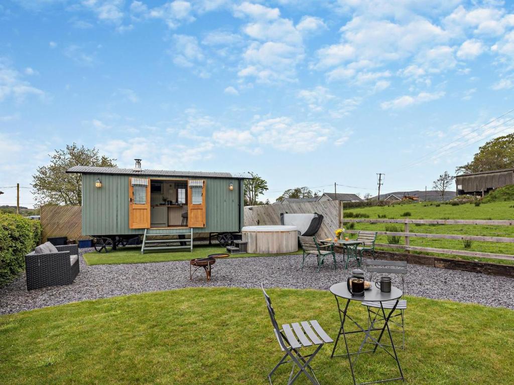 a green tiny house with a table and chairs at 1 Bed in Bala oc-85259 in Frongoch