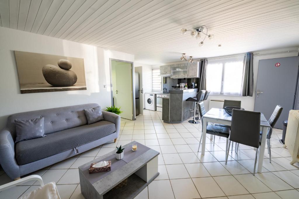 a living room with a couch and a table at Cocon chatillonnais in Châtillon-sur-Chalaronne