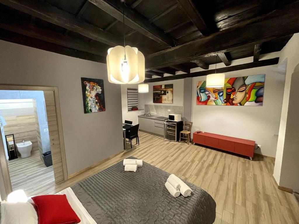 a bedroom with a bed and a living room at LE TORRI Loft Apartment in Fossano