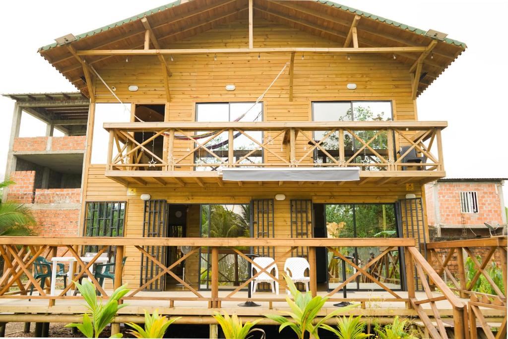 a wooden house with a deck and chairs at El Canto del Manglar in Nuquí