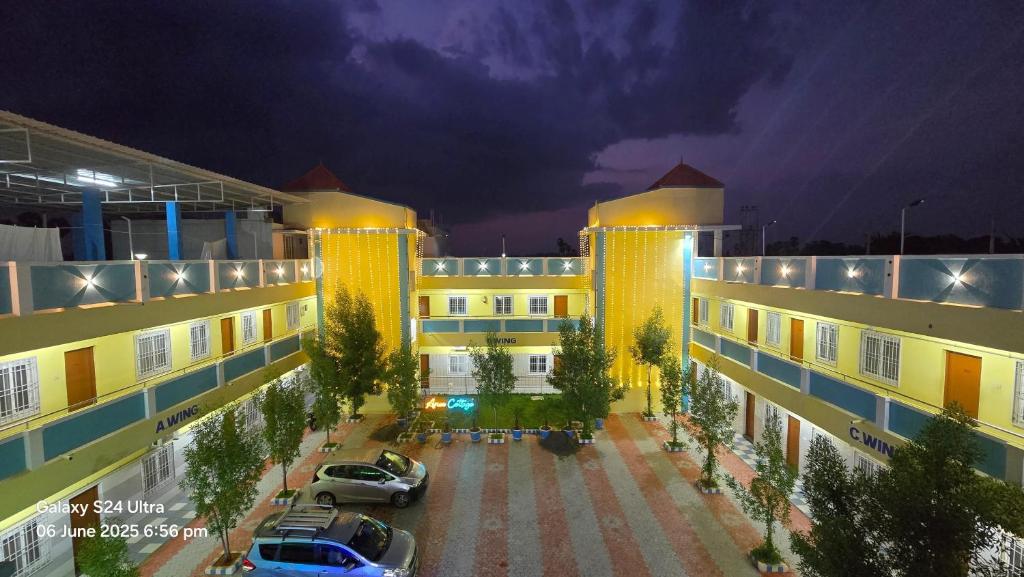 a building with cars parked in a parking lot at Arun Lodge and Cottage Near Thiruchendur in Korkai
