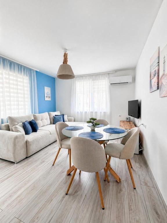 a living room with a couch and a table and chairs at Апартамент Tiana 2 in Tsarevo