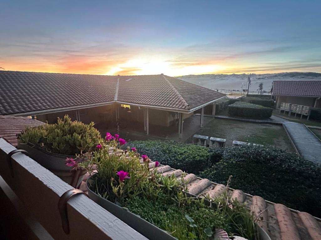 a view of a house with flowers on a balcony at Appartement Vue Sur La Dune in Seignosse
