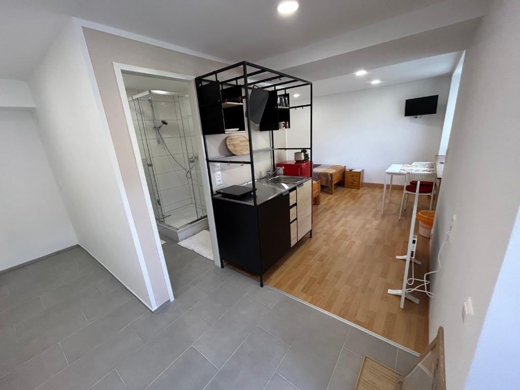 ein Wohnzimmer mit einem schwarzen Kühlschrank und einem Tisch in der Unterkunft Werkblick in Niederaigen