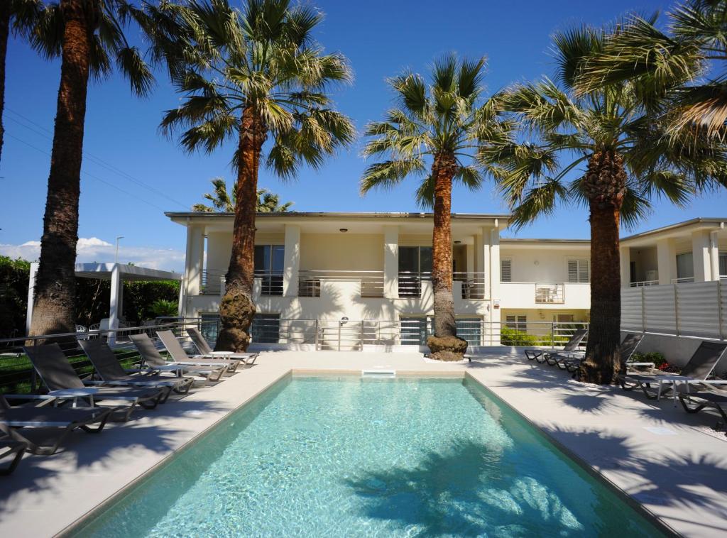 a villa with a swimming pool and palm trees at THE FLOWERs in Pontecagnano