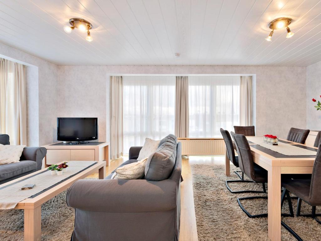 a living room with a couch and a table and chairs at Ringlaan 70 2V0201 in Wenduine