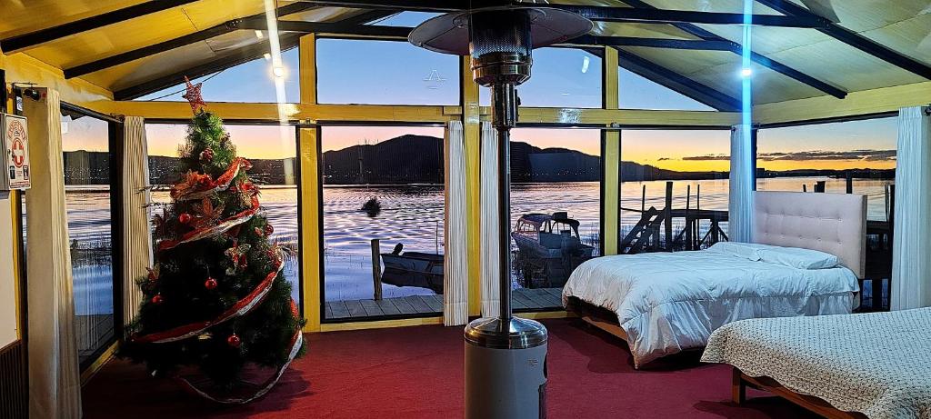 a room with a christmas tree and a bedroom at Titicaca Uros Atardecer in Puno