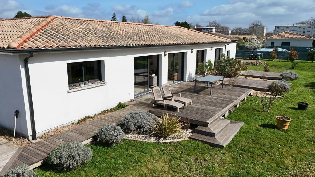 a wooden deck with a bench on a house at Maison GINKGO in Hourtin