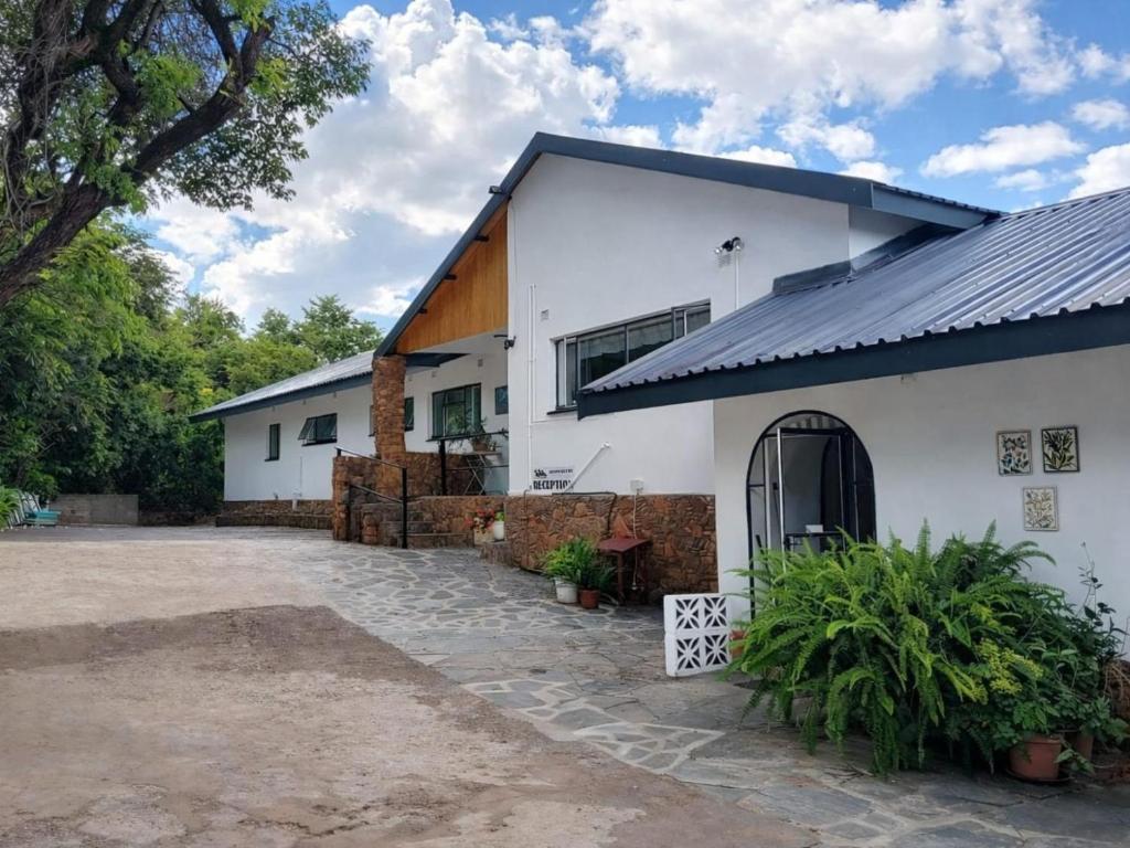 a white building with a black roof at Bushwillows B&B in Rustenburg