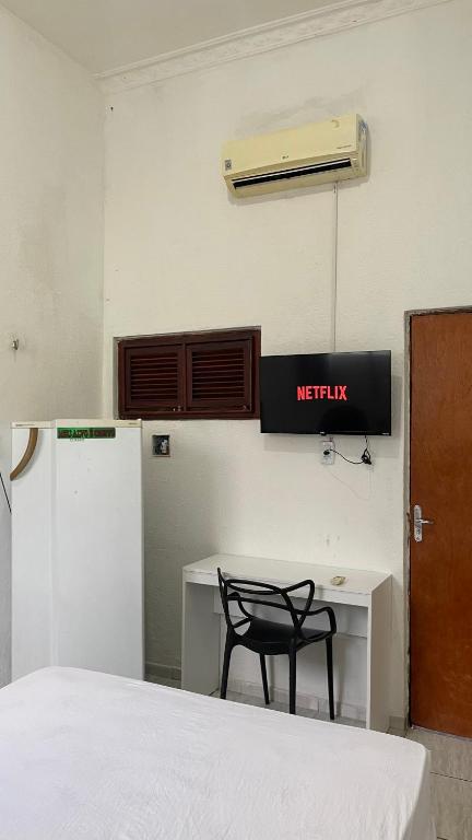 a room with a bed and a desk with a chair at Pousada Só Alegria in Fortaleza