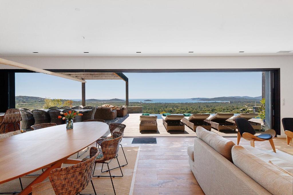 a living room with couches and a table and chairs at Villa Schena Villata in Zonza