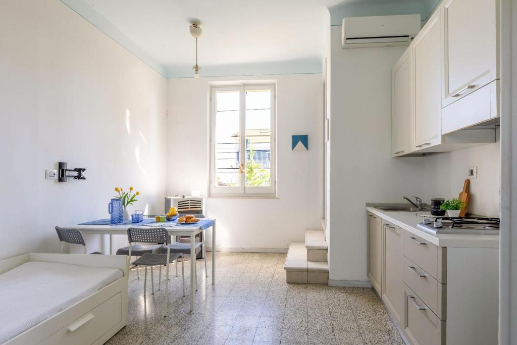 a white kitchen with a table and chairs in it at Italian Experience-Casale Oleandro Marino in Porto Recanati