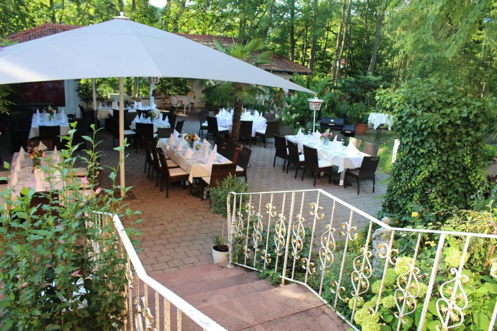 a restaurant with tables and chairs and an umbrella at Parkhotel Krone Maleck in Emmendingen