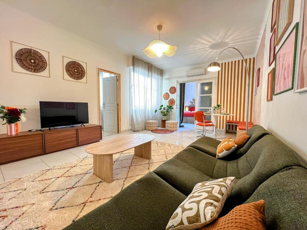 a living room with a couch and a table at Évasion azuréenne - balcon, confort à Nice in Nice
