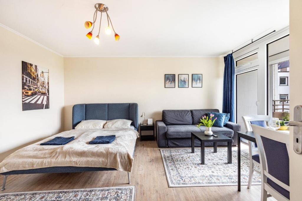 a bedroom with a bed and a couch at Panorama Suite Quickborn in Quickborn