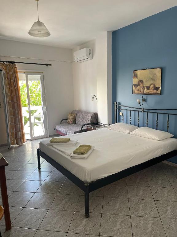 a bedroom with a large bed with a blue wall at studios costareli in Vrachonisída Diapóri