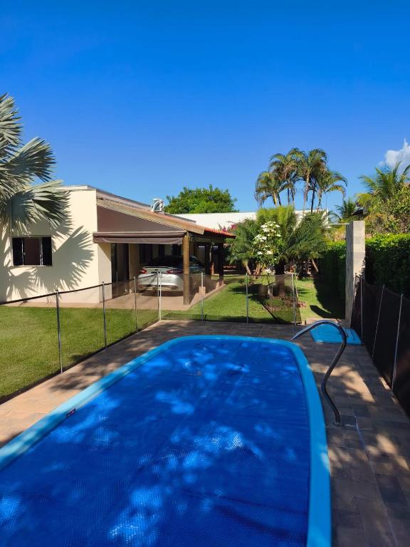 a swimming pool in front of a house at Rancho Rocha in Buritama