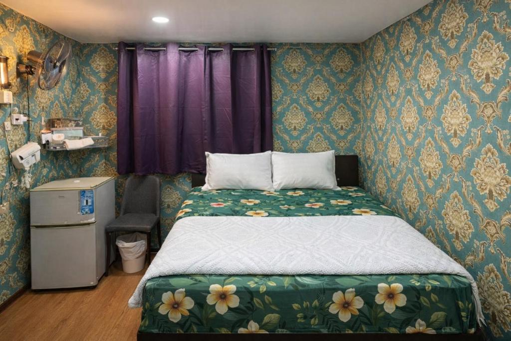 a bedroom with a bed in a room with floral wallpaper at Reliance Block C 12f in Hong Kong