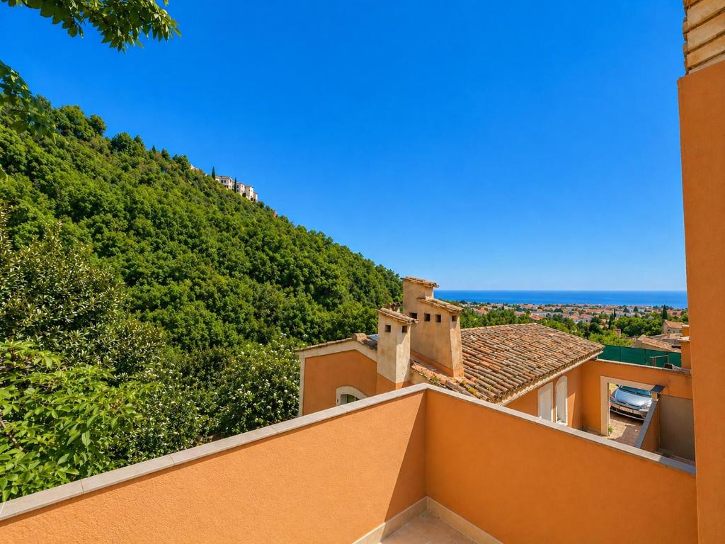 a view of a building with a hill in the background at Charmant 3 pièces avec terrasse, vue mer et parking à Vence in Vence