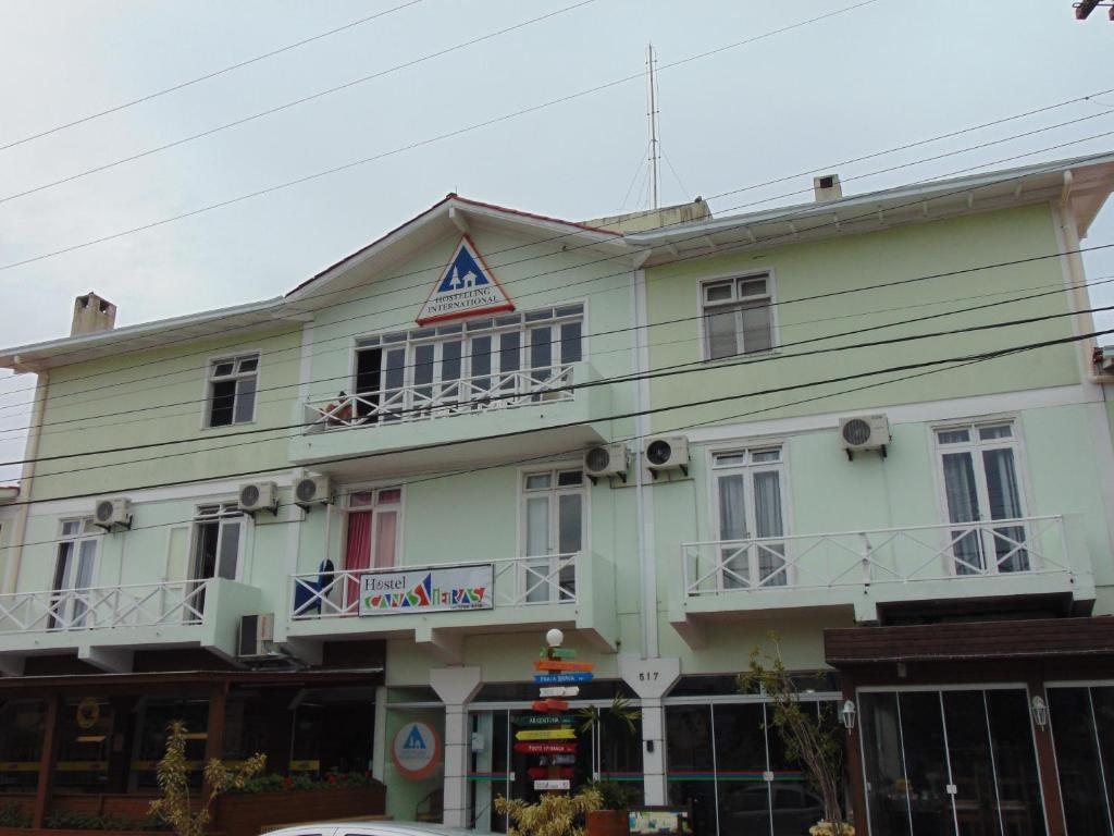 Un grand bâtiment blanc avec balcon se trouve dans une rue. dans l'établissement Hostel Canasvieiras, à Florianópolis