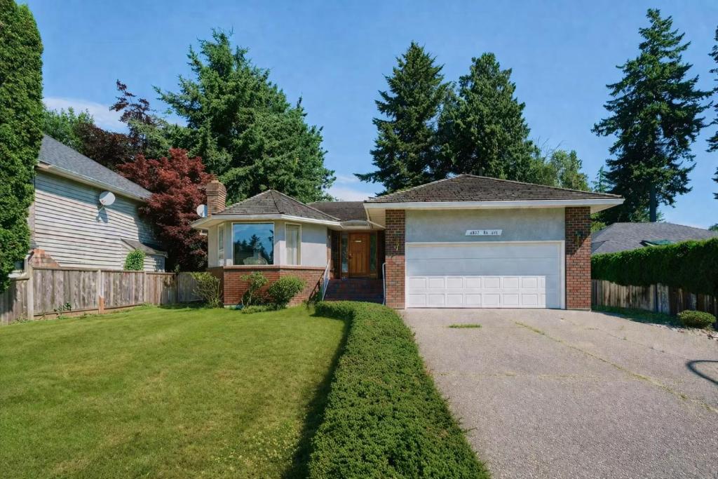 a house with a fence and a garage at Spacious house 6 bedroom near ferry in Delta