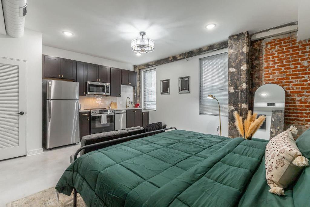 a bedroom with a green bed and a kitchen at Park Hotel Studio Suite 511 in Chattanooga