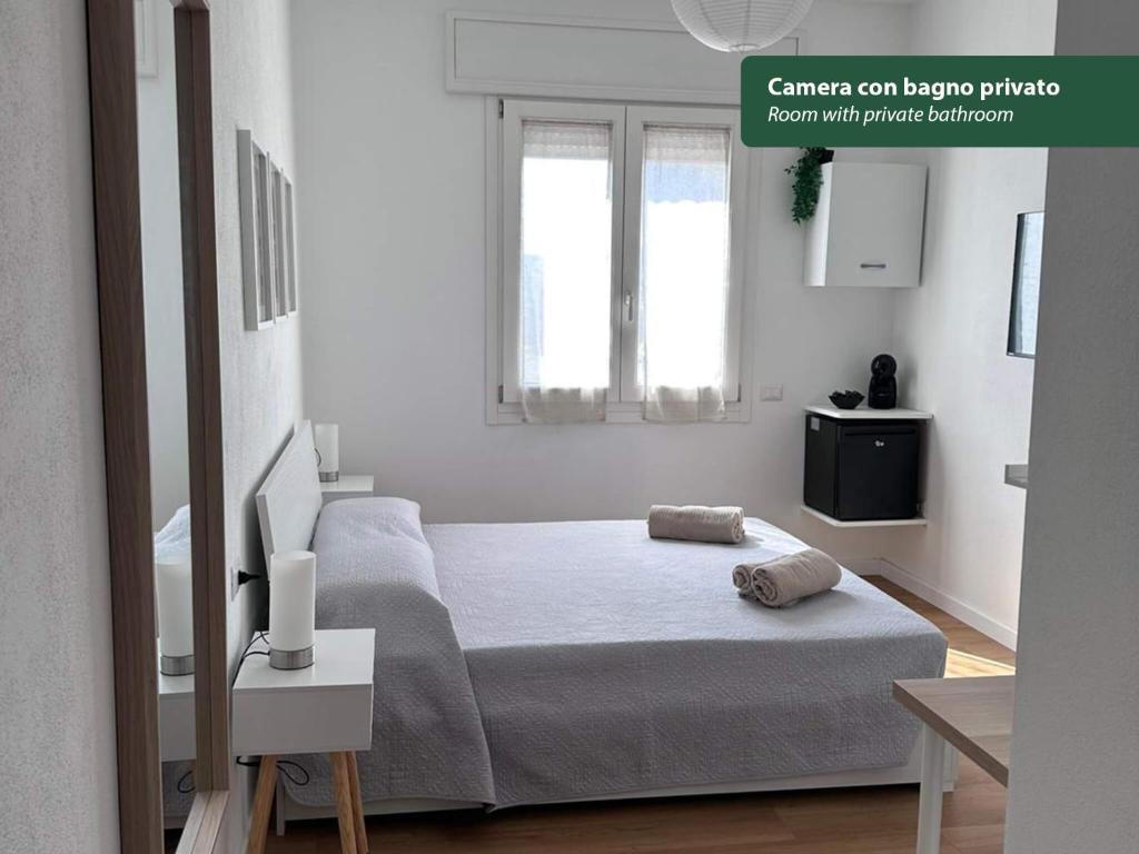 a white bedroom with a bed and a window at Isola Chiara in Cagliari